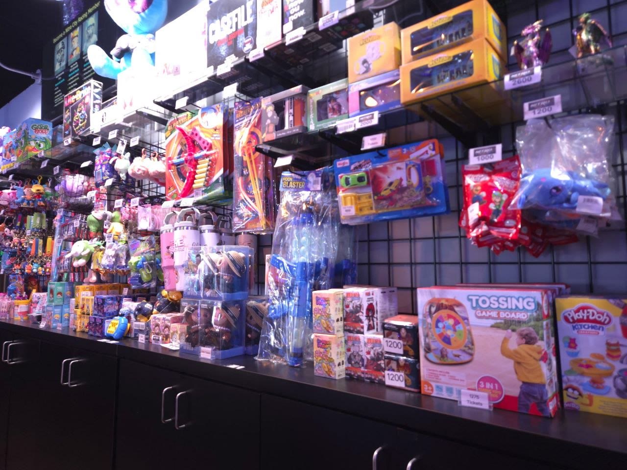 The prize wall at Amped Arcade Rohnert Park, stacked with ticket-priced toys, plushes, and games
