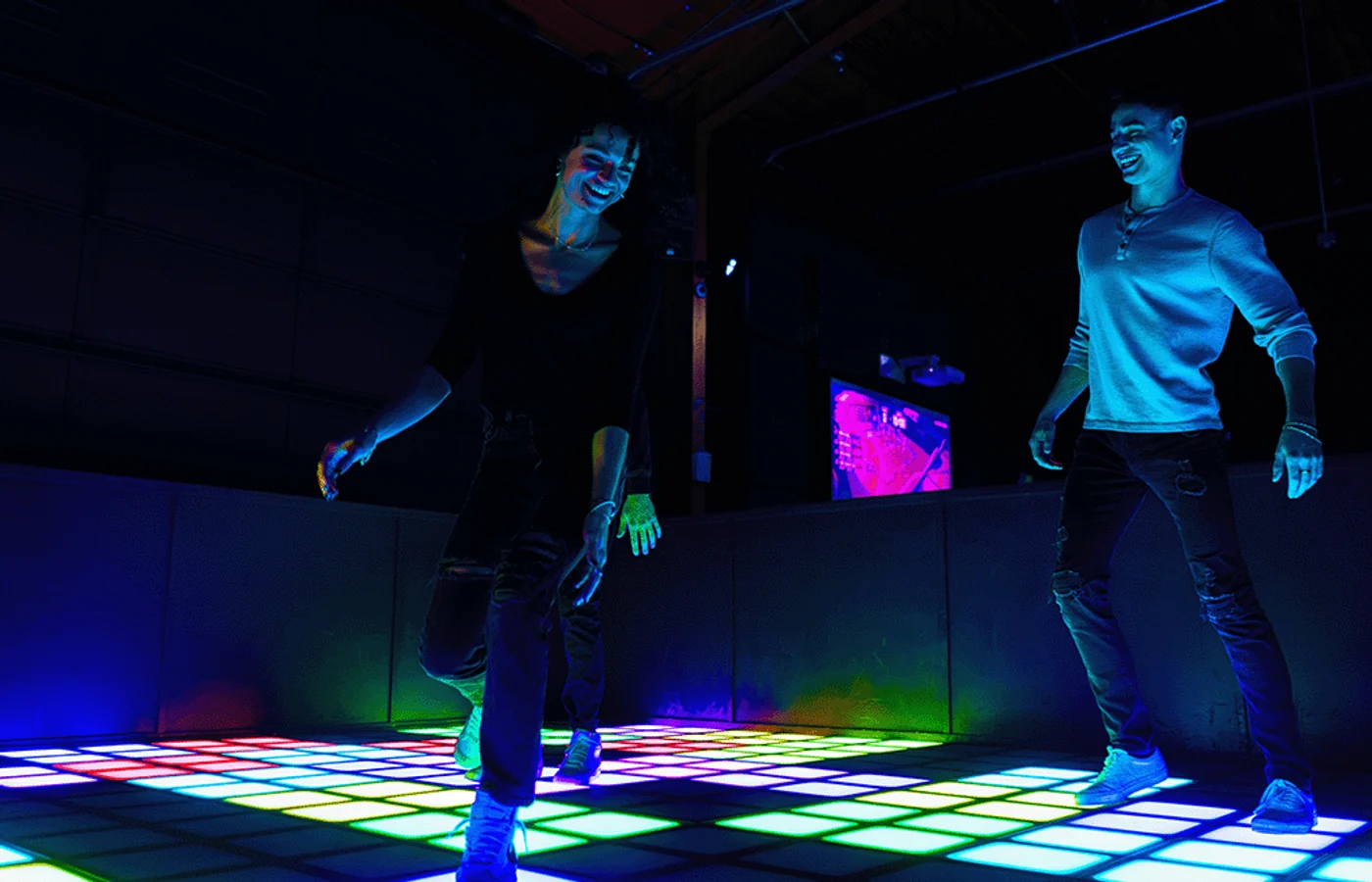 Players moving across the glowing Pixels floor at Nitro City Racing Fairfield