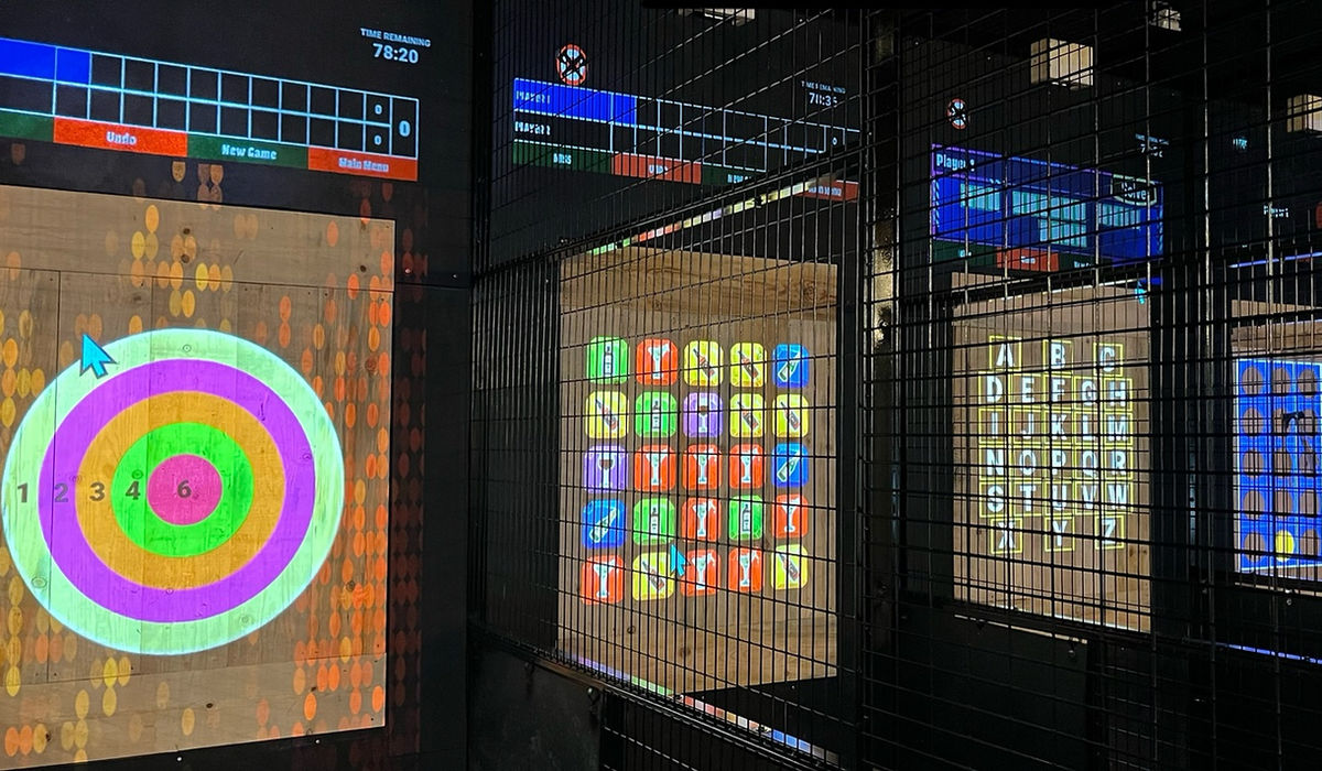 Projected axe-throwing targets glowing across the lanes at Nitro City Racing