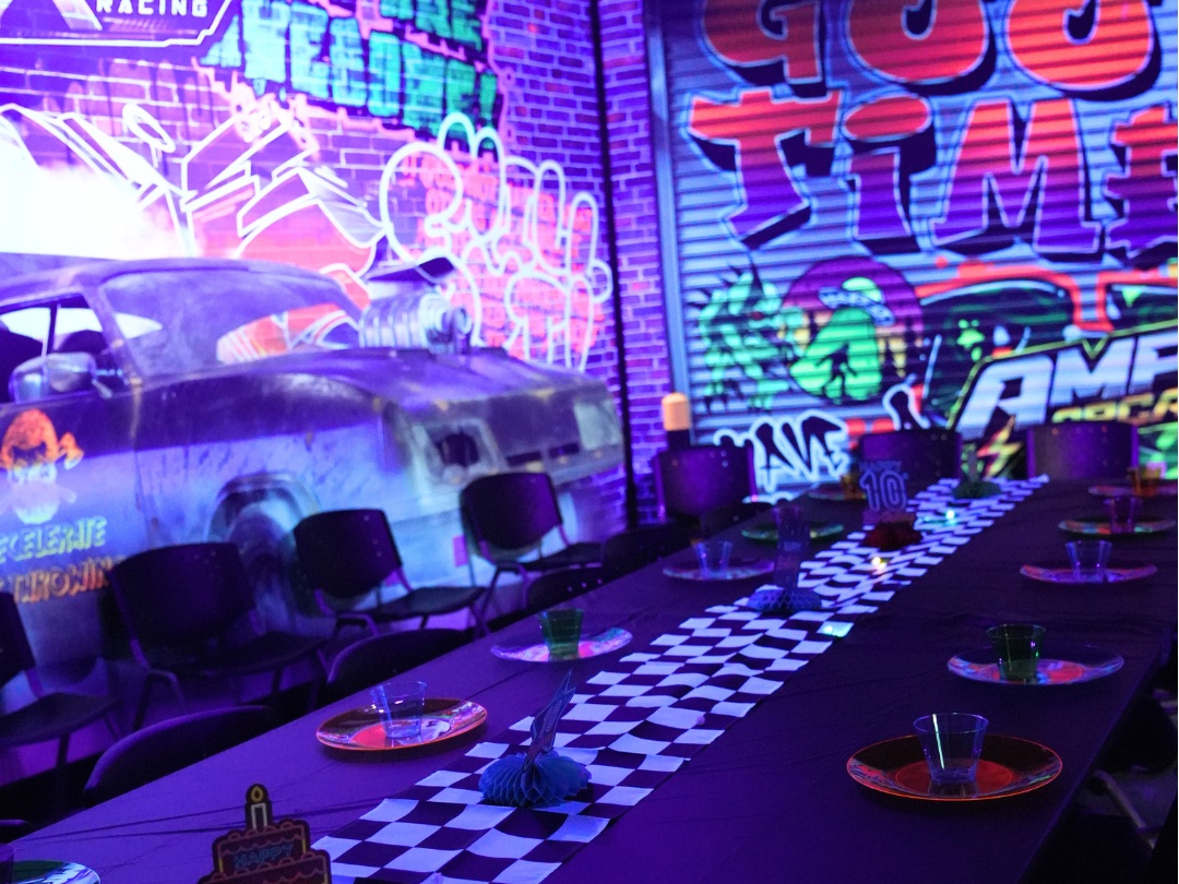 Blacklight party area in Fairfield with graffiti walls and a checkered birthday table